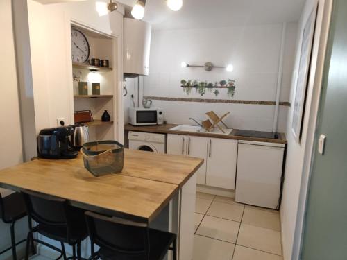 une cuisine avec des armoires blanches et un comptoir en bois dans l'établissement centre ville proche du métro, à Toulouse