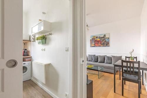 un salon et une cuisine avec un canapé et une table dans l'établissement Parisian Paradise Beautiful Apartment, à Villejuif