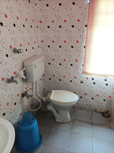 a bathroom with a toilet and a sink at Kirtti Inn Mini Home Non AC in Lokpriya Gopinath Bordoloi International