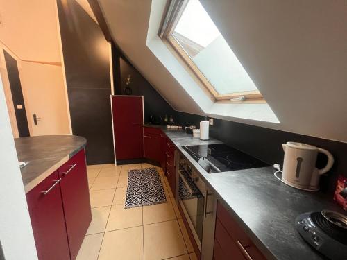 a kitchen with red cabinets and a window at Appartement 70m2 Illkirch centre in Illkirch-Graffenstaden