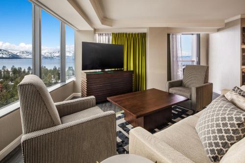 a living room with a television and a couch and chairs at Caesars Republic Lake Tahoe in Stateline