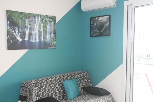 a living room with blue walls and a couch at T2 moderne avec terrasse a 100m de la plage et parking sécurisé 4 PERS MAXI in Saint Pierre La Mer