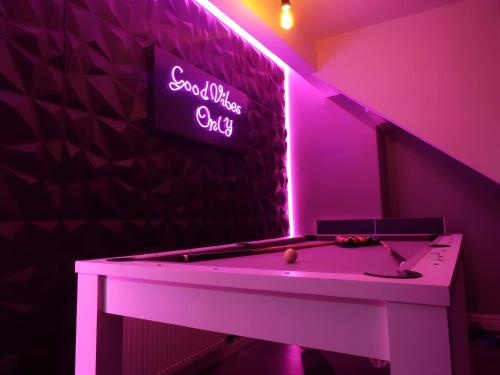 a pool table in a room with a neon sign at Toller Heights in Bradford