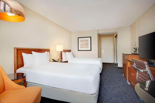 a hotel room with two beds and a television at Hilton Chicago O'Hare Airport in Rosemont
