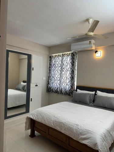 a bedroom with a large bed and a mirror at Aami dhivahi guest house 03 in Trivandrum