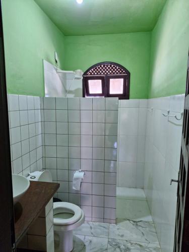 a green bathroom with a toilet and a sink at Byttebier in Conde