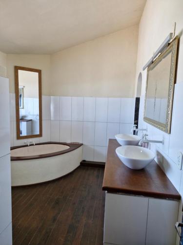 a bathroom with two sinks and a bath tub at Byttebier in Conde