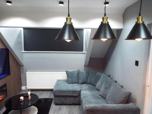 a living room with a couch and two pendant lights at Toller Heights in Bradford