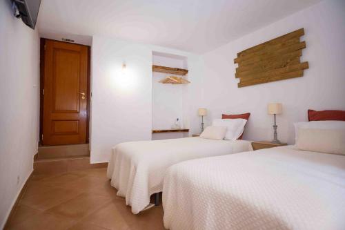 two beds in a room with white walls at Refúgio Alentejano in Alandroal