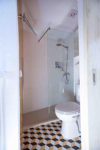 a bathroom with a toilet and a glass shower at Refúgio Alentejano in Alandroal