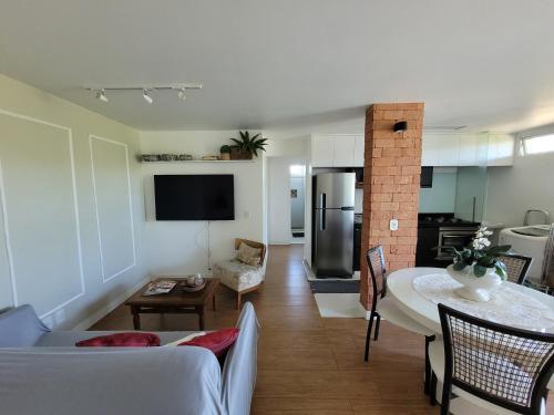 Il comprend un salon avec une table à manger et une cuisine. dans l'établissement Centro de Búzios 2 quartos, à Búzios