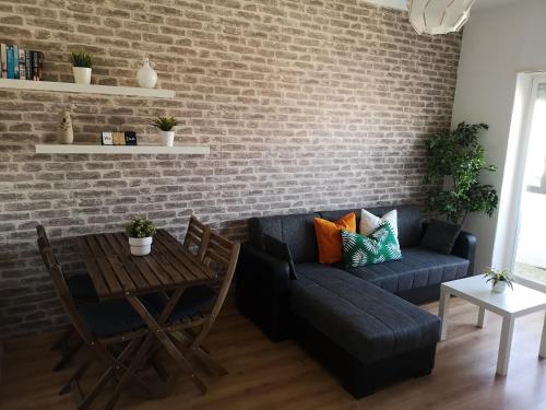 a living room with a blue couch and a brick wall at City Centre Apartment Setubal in Setúbal