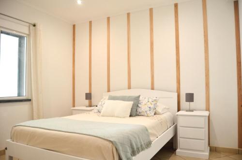 a bedroom with a bed and a striped wall at House Fifteen in Horta