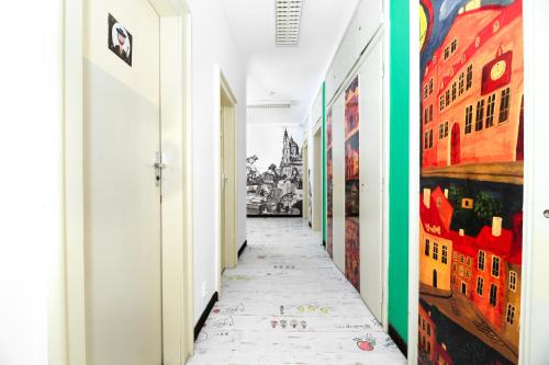 a hallway with colorful paintings on the walls at Benedikt City Center Hostel in Prague