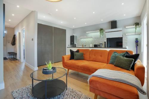 a living room with an orange couch and a table at The Northern House - Grampian Lettings in Aberdeen