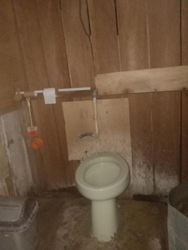 a bathroom with a white toilet in a wooden room at Nyandetor Homestay in Yennanas Besir