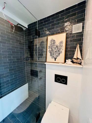 a bathroom with a shower and a toilet and a picture at Nautical living in Manly in Sydney