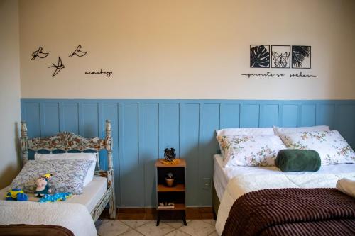 a bedroom with two beds and a wall with birds on it at Apartamentos exclusivos e equipado com varanda ou terraço com Pôr do sol, cozinha privativa, Wi-Fi 600MBs, a 700m da praia de Itapirubá e 1km da BR-101 in Imbituba