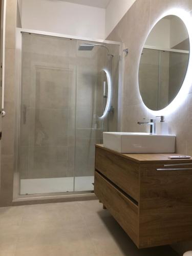 a bathroom with a sink and a shower with a mirror at Casa de Mama in Trieste