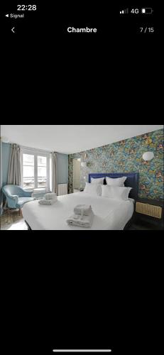 une chambre avec un grand lit blanc avec une tête de lit bleue dans l'établissement La tanière Mandar, à Paris