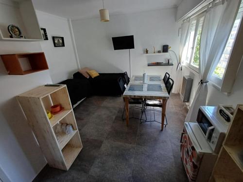 Una pequeña sala de estar con una mesa y un sofá. en Falucho 1574 Zona Aldrey 200mts Guemes, 300mts Playa, en Mar del Plata