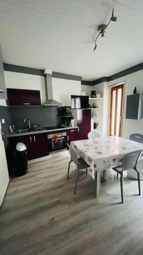 une cuisine avec une table et des chaises dans une pièce dans l'établissement Bel appartement 50 m télécabines 200 m village, à Cauterets