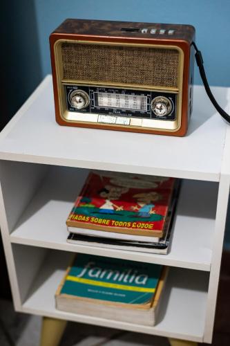an old radio sitting on top of a shelf at Apartamentos exclusivos e equipado com varanda ou terraço com Pôr do sol, cozinha privativa, Wi-Fi 600MBs, a 700m da praia de Itapirubá e 1km da BR-101 in Imbituba