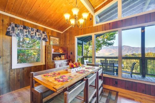 a dining room with a table and large windows at Hot Tub and Mountain Views at Gatlinburg Cabin! in Gatlinburg