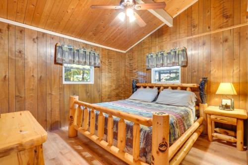 a bedroom with a bed in a room with wooden walls at Hot Tub and Mountain Views at Gatlinburg Cabin! in Gatlinburg