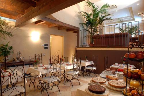 Hotel Del Borgo في بولونيا: غرفة بها طاولات وكراسي عليها طعام