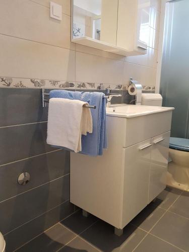 a bathroom with a sink and a toilet and towels at Apartment Desa in Bol