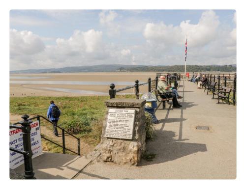 a group of people sitting on benches near the beach at Sunnycote in Arnside