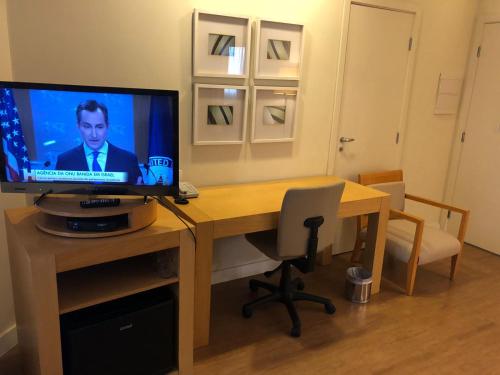 a room with a desk with a television on it at Flat Nobilis confortavel em frente ao Aeroporto Congonhas - H305 in Sao Paulo