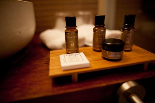 three bottles of essential oils on a wooden table at Mas del Bot in Valderrobres