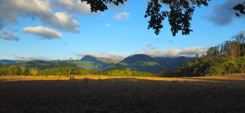 a view of a field with mountains in the background at Cabana Du Sítio in Praia Grande