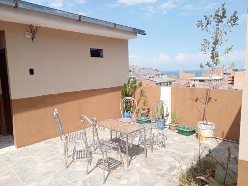 a patio with a table and chairs on a balcony at Hostal Puerto Alegre in Copacabana