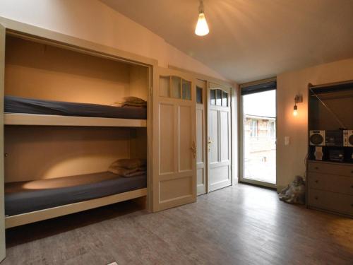 a room with bunk beds and a hallway with a door at Gutshofblick L in Hanshagen