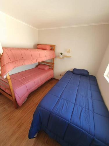a bedroom with a bed and a bunk bed and a bed at Departamento Laguna del Mar in La Serena