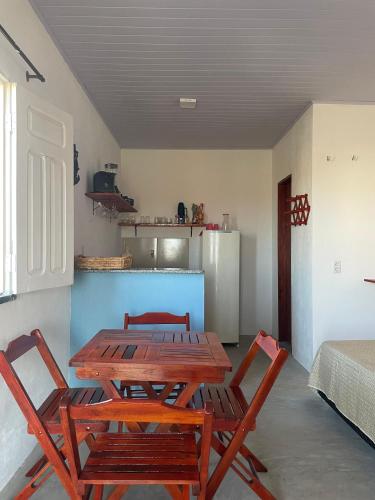 a kitchen with a wooden table and chairs at Villa Careca in Luis Correia
