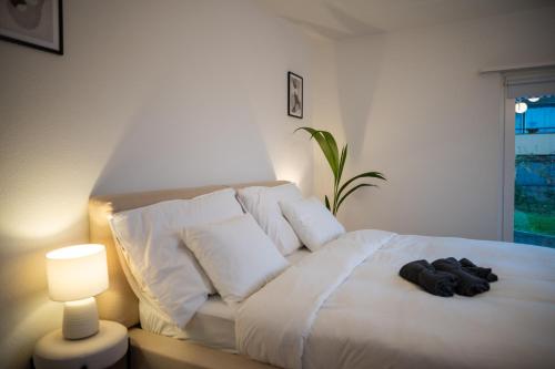 a bedroom with a white bed with a robe on it at Sky Paradise 20min to zurich city centre in Widen
