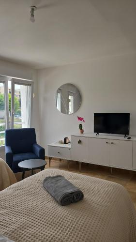une chambre avec un lit, une télévision et une chaise dans l'établissement Appart'City village, à Trappes
