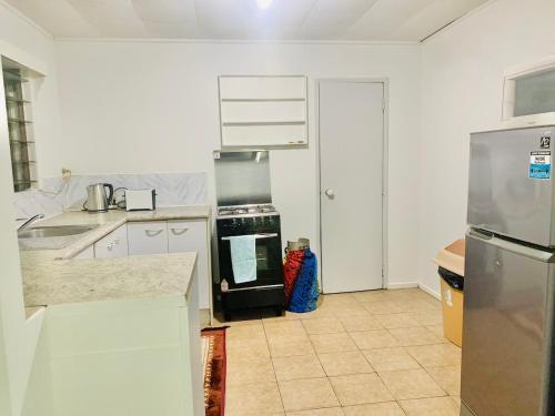 a kitchen with a stove and a refrigerator at Ocean Cottage - Entire Place in Nukualofa Town Center in Nuku‘alofa