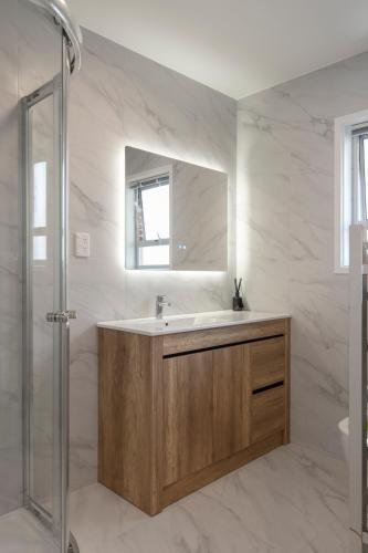 a bathroom with a sink and a mirror at Beckenham Garden in Auckland