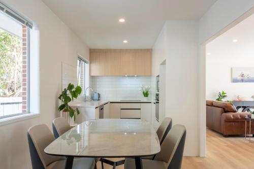 a kitchen and dining room with a table and chairs at Beckenham Garden in Auckland