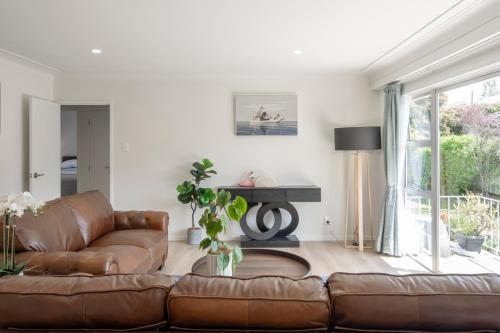 a living room with a brown leather couch at Beckenham Garden in Auckland