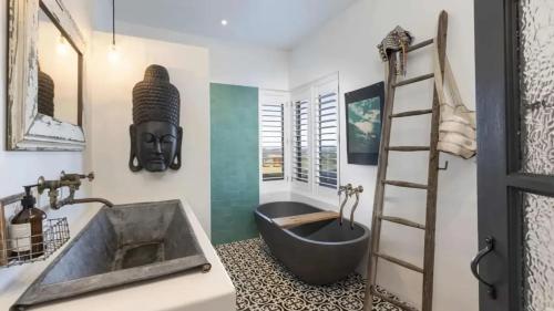 a bathroom with a bath tub and a sink at Hogans Bluff in Coopers Shoot