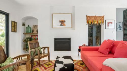 a living room with a red couch and a fireplace at Hogans Bluff in Coopers Shoot