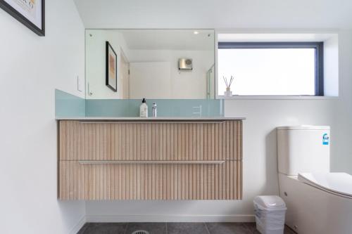 a bathroom with a sink and a mirror at Modern 6BD Homes Carpark Avebury Park Avon River in Christchurch