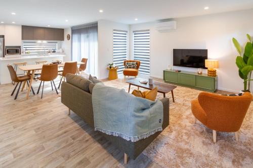 a living room with a couch and a table at Modern 6BD Homes Carpark Avebury Park Avon River in Christchurch