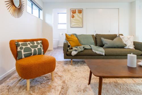 a living room with a couch and a chair at Modern 6BD Homes Carpark Avebury Park Avon River in Christchurch